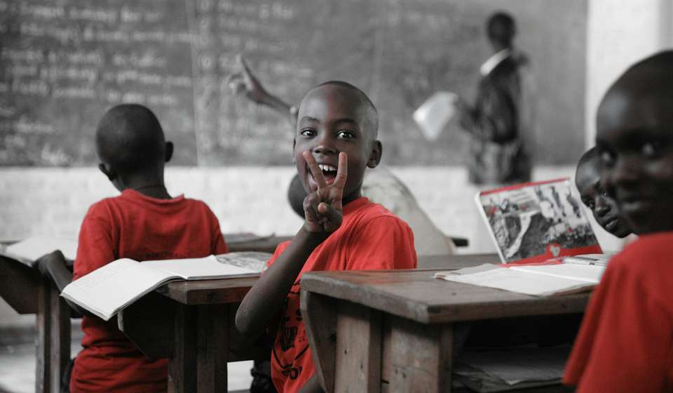 A learner smiling from a classroom desk